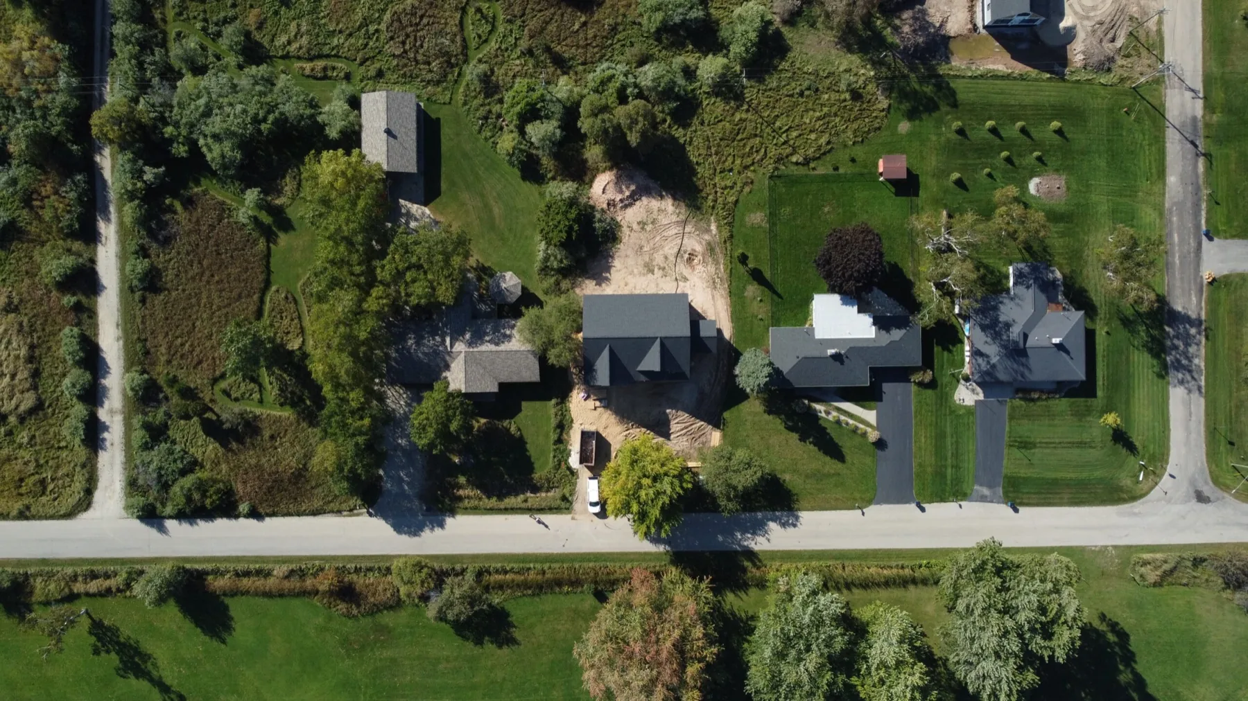 Aerial view of a residential property and the land around it